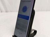 a close up of a cell phone on a stand on a bed