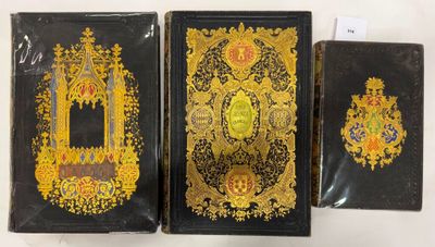 trois couvertures de livres noires et dorées ornées de motifs élaborés