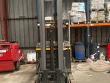 a forklift in a warehouse with a lot of boxes on the shelves