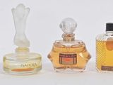 five bottles of perfume sitting next to each other on a white surface
