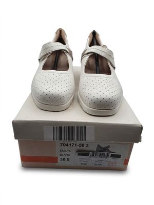 une paire de chaussures blanches pour femme dans une boîte, sur fond blanc