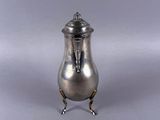 an antique silver plated teapot on stand on a grey background