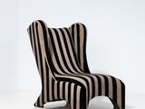 une chaise rayée dans une pièce blanche, avec une chaise rayée en noir et blanc