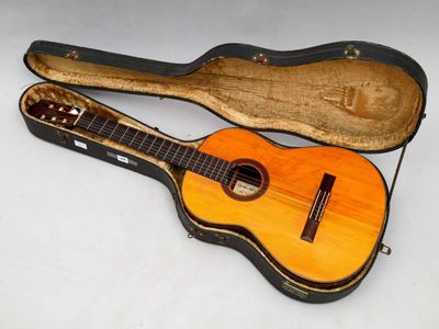 une image représentant une guitare dans son étui, posée sur une surface blanche
