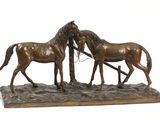 bronze statue of three horses standing on a rock with a white background
