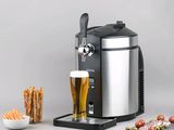 un gros plan d'un distributeur de bière avec un verre de bière à côté