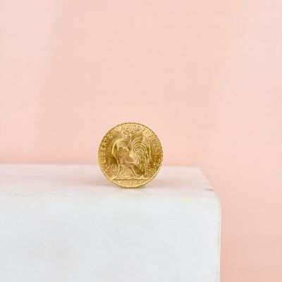 a gold coin sitting on top of a white pedestal