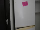 a white refrigerator with a pink sticker on it