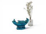 a vase with a book and a vase with a plant in it