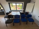des chaises et une table dans une pièce où se trouve un tableau blanc accroché au mur