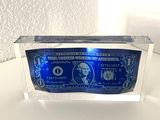 a close up of a blue and white paper money in a clear box