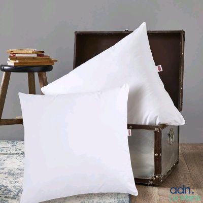 une paire de coussins blancs posés sur une table en bois