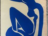 a blue and white painting of a woman sitting on the ground