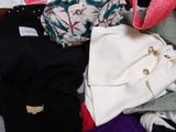 a pile of clothes that is sitting on a bed