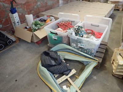 de nombreux cartons contenant des vêtements et d'autres objets, posés par terre