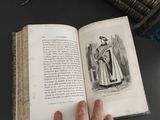a person holding an open book on a table