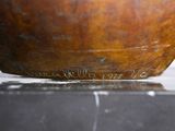 a wooden bowl with writing on it on a table