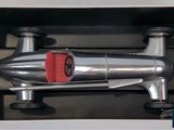 a silver and red object in a black box