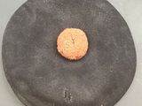 a doughnut sitting on a black plate on a table