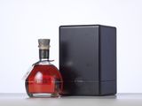 a bottle of red wine sitting next to a black box
