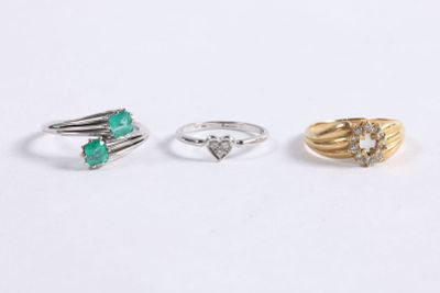 trois bagues différentes, dont une avec une pierre verte et une autre avec un diamant