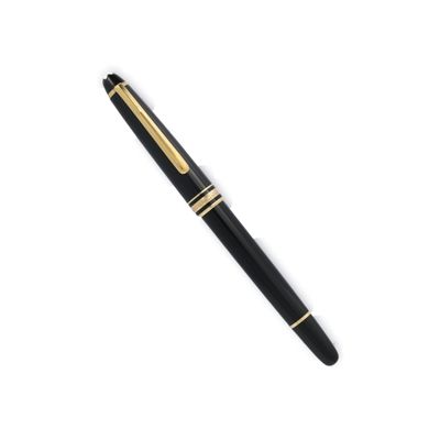 un stylo noir et or posé sur une surface blanche