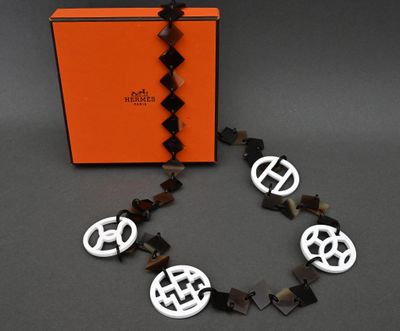 an orange box with a black and white necklace and a black and white bracelet