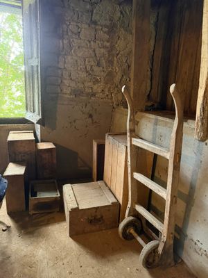 une pièce avec une échelle, une chaise, une table et une fenêtre