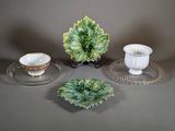 three plates and cups on a table with a plant in the background