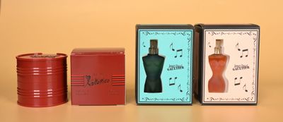 three boxes of perfume sitting on a table next to each other
