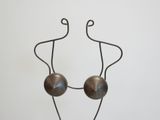 metal sculpture of a woman with two balls on her head