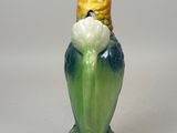 a figurine of a bird sitting on top of a corn cob