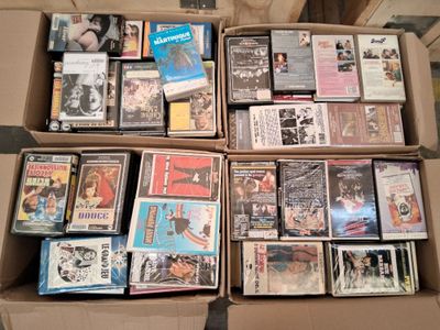 un grand nombre de dvd dans une boîte posée sur le sol