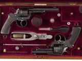a wooden case with a gun and other items in it