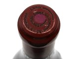 a close up of a bottle of wine on a white surface