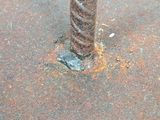 a close up of a rusted metal pole on the ground