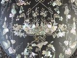 a black plate with white flowers and birds on it