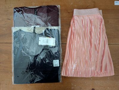 two pairs of skirts sitting on a table next to each other