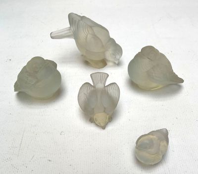 six oiseaux en verre posés sur une surface blanche