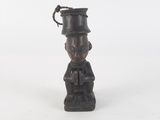 une petite statue d'un homme avec un chapeau sur la tête