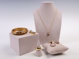une vitrine blanche contenant une bague, un bracelet, un porte-bague et d'autres bijoux