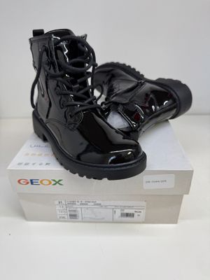 une paire de bottes noires posée sur une boîte
