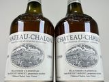 two bottles of chateau - chalon wine sitting on top of a white table