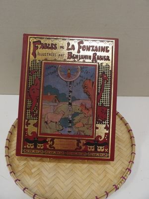 an old book is sitting on top of a basket on a table