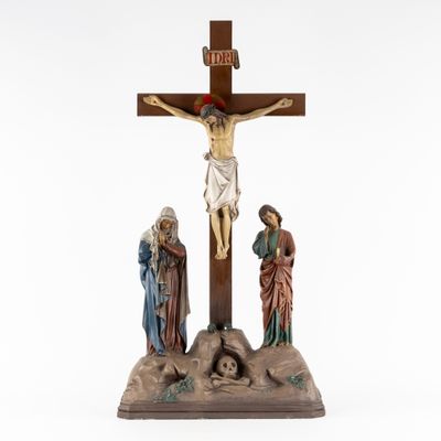 a statue of jesus on the cross with three people