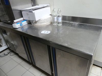 un plan de travail en acier inoxydable sur lequel sont posées deux bouteilles d'eau