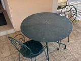 une table et des chaises sur la terrasse à l'extérieur d'un immeuble