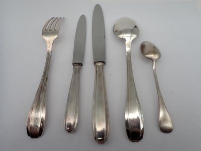 four forks, a knife, and a spoon on a table