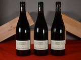 three bottles of wine sitting next to a wooden box