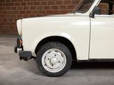a small white car parked in front of a brick wall